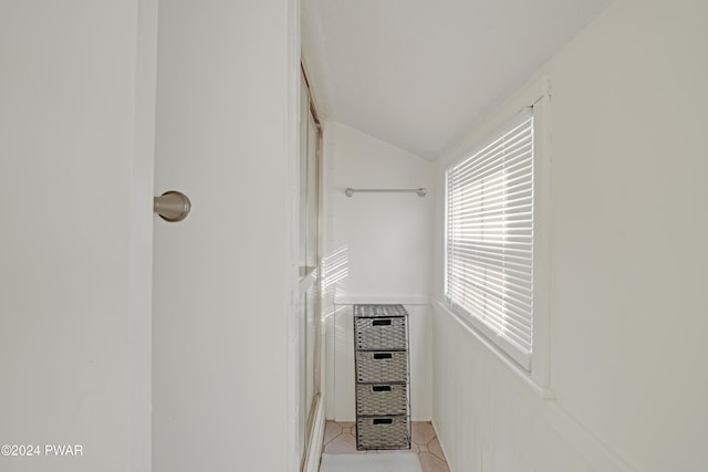 walk in closet with vaulted ceiling and light tile patterned flooring