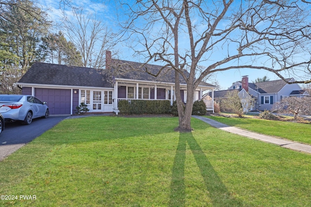 ranch-style home featuring covered porch, a garage, and a front lawn