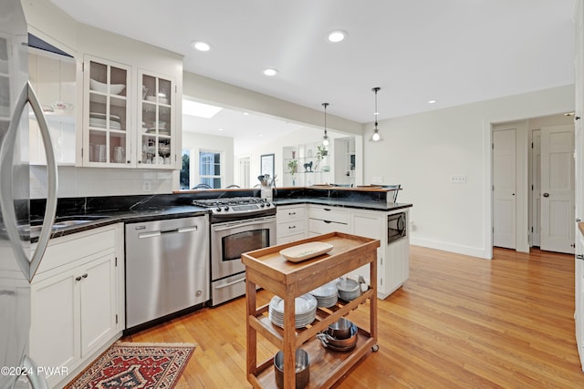 kitchen with tasteful backsplash, white cabinetry, pendant lighting, and appliances with stainless steel finishes