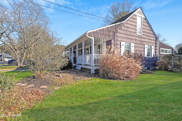 view of side of property with covered porch and a lawn