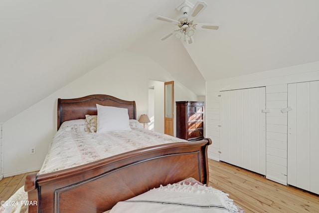 bedroom with ceiling fan, vaulted ceiling, light wood-type flooring, and a closet