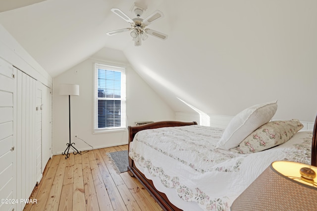 bedroom featuring ceiling fan, lofted ceiling, and light wood-type flooring