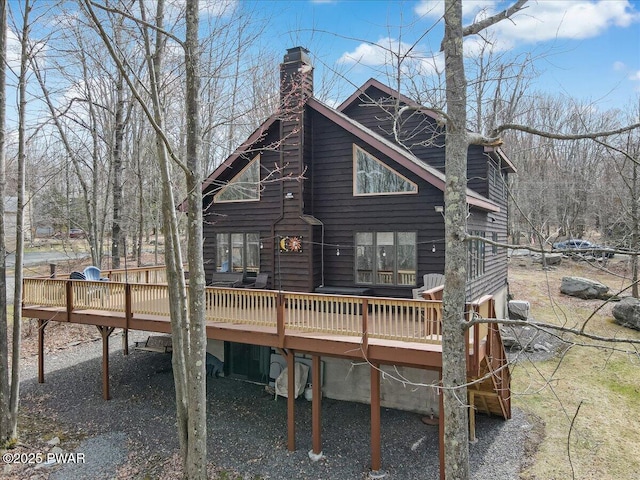 rear view of property with a chimney and a deck