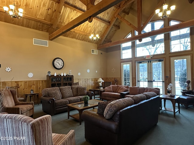 living area featuring a wainscoted wall, visible vents, and an inviting chandelier