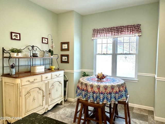 dining room with stone finish flooring and baseboards