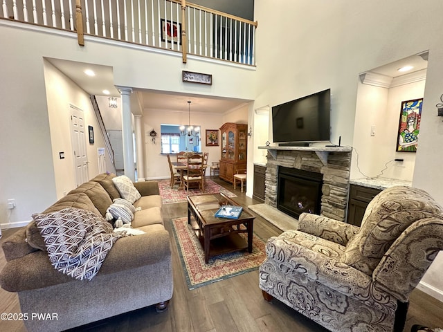 living room with ornamental molding, wood finished floors, a towering ceiling, and baseboards