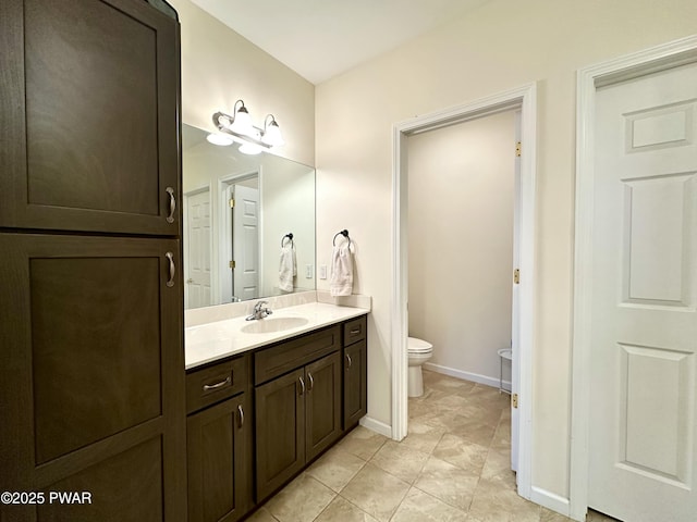 bathroom featuring vanity, toilet, and baseboards