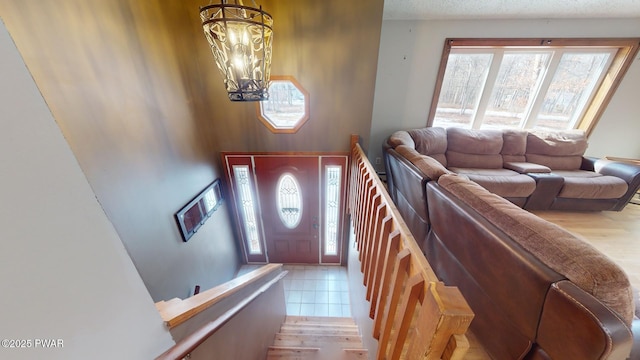 tiled entryway with an inviting chandelier