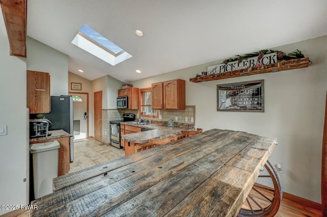 1007 Apache Ct, Lake Ariel, PA 18436 - kitchen featuring stainless steel appliances, lofted ceiling, a skylight, backsplash, and a sink