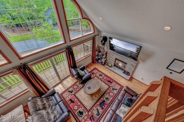 1007 Apache Ct, Lake Ariel, PA 18436 - living area with wood finished floors, a glass covered fireplace, high vaulted ceiling, and recessed lighting