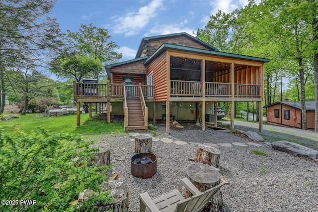 1007 Apache Ct, Lake Ariel, PA 18436 - back of house with a fire pit, stairway, a deck, and faux log siding