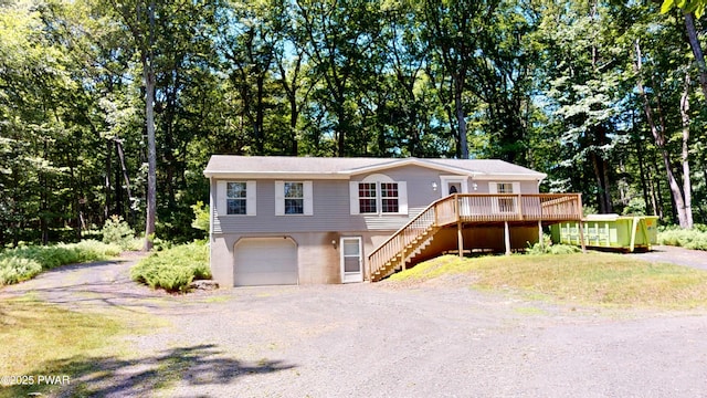 103 Windwards Ln, Dingmans Ferry, PA 18328 - view of front of house with driveway, a garage, a deck, stairway, and view of wooded area