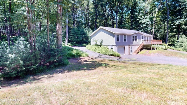 103 Windwards Ln, Dingmans Ferry, PA 18328 - view of property exterior with stairway, driveway, a garage, a deck, and a lawn