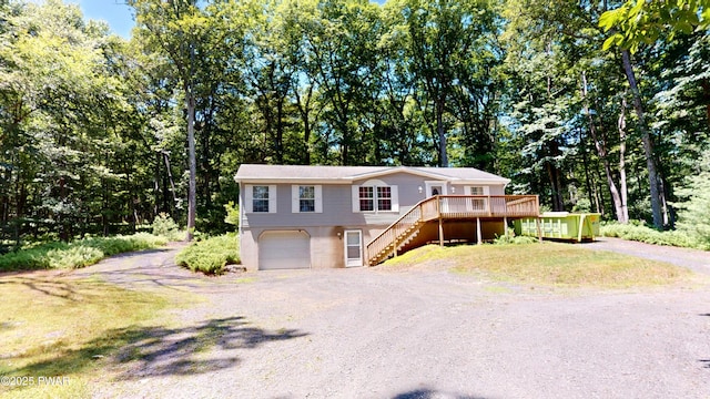103 Windwards Ln, Dingmans Ferry, PA 18328 - ranch-style home with driveway, stairway, an attached garage, and a wooden deck