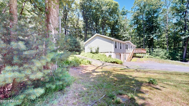 103 Windwards Ln, Dingmans Ferry, PA 18328 - view of property exterior featuring a wooden deck, asphalt driveway, stairway, and a lawn