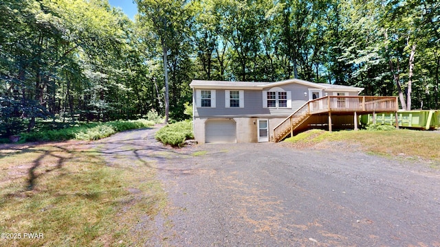 103 Windwards Ln, Dingmans Ferry, PA 18328 - view of front of home with stairs, driveway, a wooden deck, an attached garage, and view of wooded area