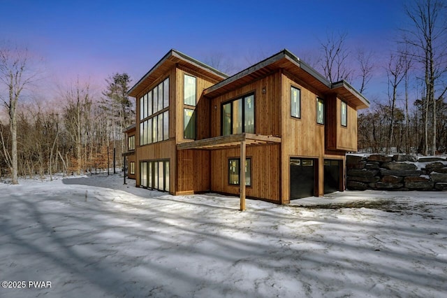 view of snowy exterior featuring a garage