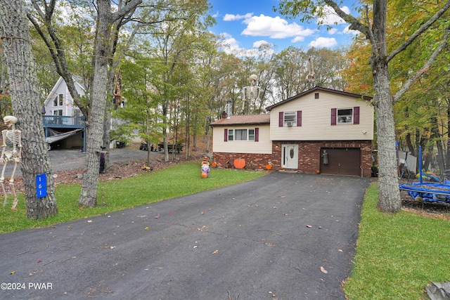 tri-level home with a garage and a front lawn