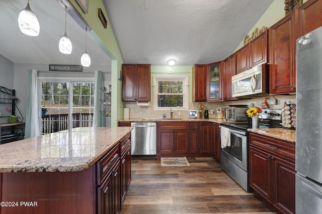 kitchen featuring decorative light fixtures, dark hardwood / wood-style flooring, appliances with stainless steel finishes, and tasteful backsplash