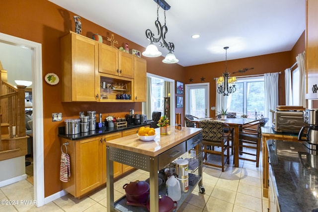 kitchen featuring pendant lighting, butcher block countertops, light tile patterned floors, and a chandelier