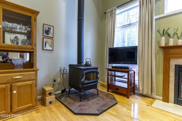 sitting room with light wood-type flooring and a wood stove