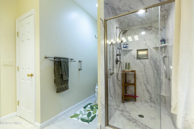 bathroom featuring tile patterned floors, toilet, and a shower with door