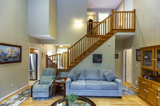 living room featuring a high ceiling and light hardwood / wood-style flooring