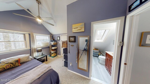 bedroom with lofted ceiling with skylight, multiple windows, baseboards, and light colored carpet