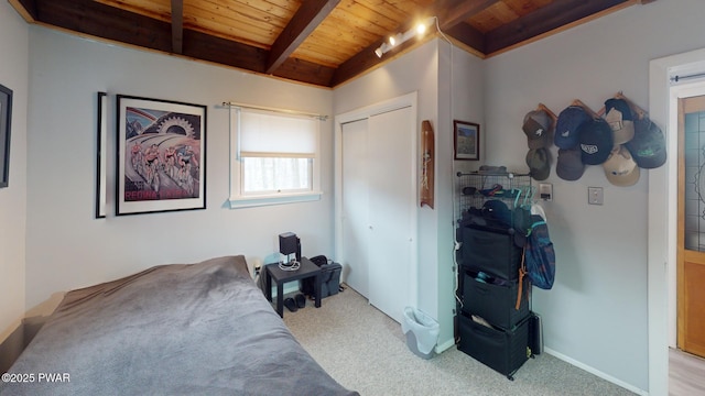 bedroom featuring a closet, beam ceiling, wooden ceiling, and carpet floors