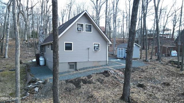 view of property exterior featuring a shed, cooling unit, and an outdoor structure