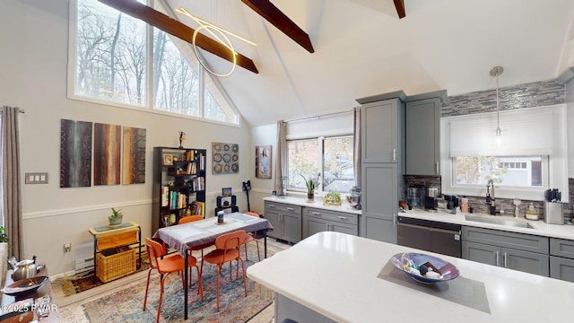 kitchen featuring dishwasher, gray cabinets, a sink, and light countertops