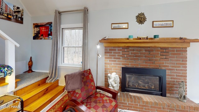 living area with a fireplace, baseboards, and wood finished floors