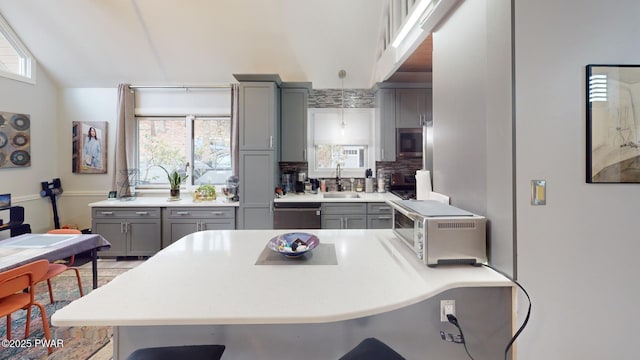 kitchen with stainless steel appliances, gray cabinets, plenty of natural light, and a kitchen breakfast bar