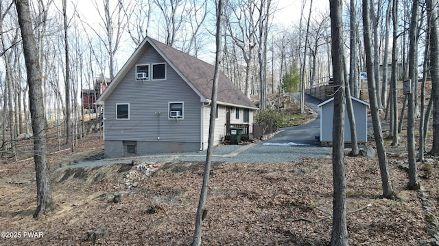 view of side of home with a shingled roof