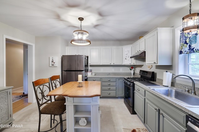 102 Circle Dr, Milford, PA 18337 - kitchen featuring freestanding refrigerator, gas stove, under cabinet range hood, gray cabinetry, and white cabinetry