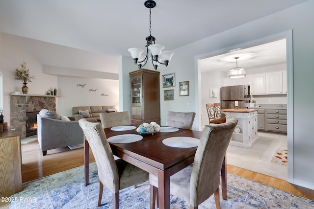 102 Circle Dr, Milford, PA 18337 - dining space featuring light wood finished floors, a chandelier, and a fireplace