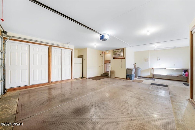 garage featuring white refrigerator and a garage door opener