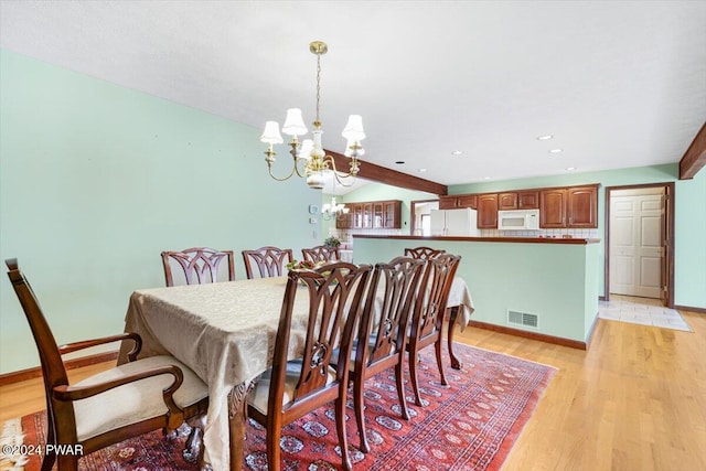 dining room featuring vaulted ceiling with beams, light wood-type flooring, and an inviting chandelier