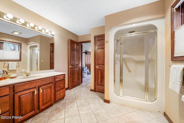 bathroom with tile patterned floors, vanity, and walk in shower