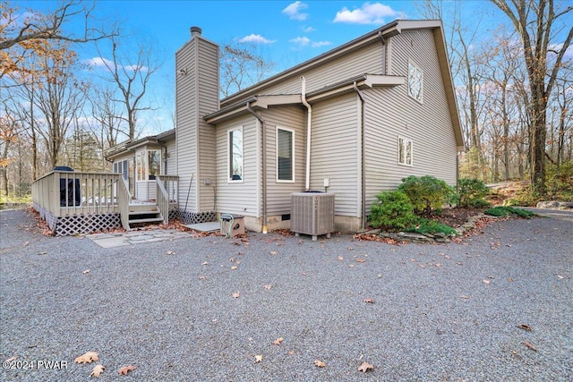 view of side of home with central AC and a deck