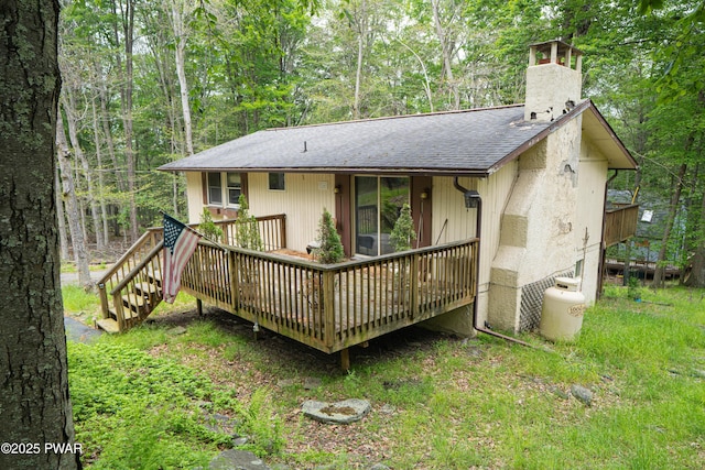 1032 Deer Field Ct, Lake Ariel, PA 18436 - back of property with a chimney, a shingled roof, a wooden deck, and a forest view