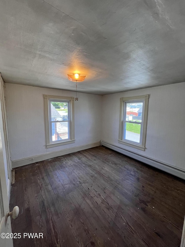 109 N St, Forest City, PA 18421 - empty room featuring a baseboard radiator, plenty of natural light, dark wood finished floors, and a textured ceiling