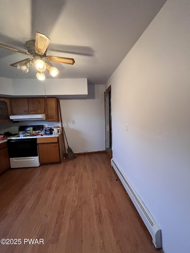 kitchen with under cabinet range hood, a baseboard heating unit, white electric range oven, wood finished floors, and light countertops