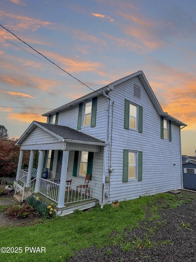 view of front of home with a porch and a lawn