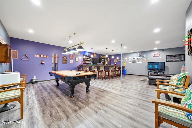 game room featuring light hardwood / wood-style flooring, indoor bar, and pool table