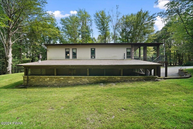 rear view of house featuring a yard