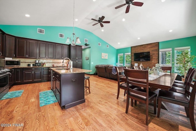 kitchen with sink, decorative backsplash, decorative light fixtures, a breakfast bar area, and stainless steel appliances