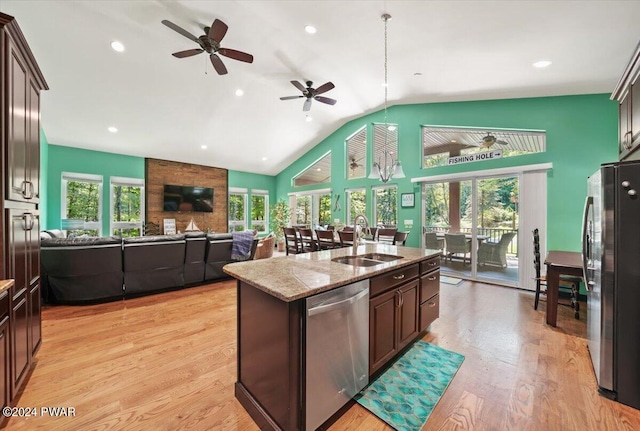 kitchen with sink, light stone counters, an island with sink, appliances with stainless steel finishes, and light wood-type flooring