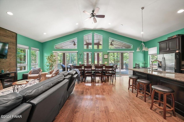 living room with ceiling fan, light wood-type flooring, sink, and a wealth of natural light