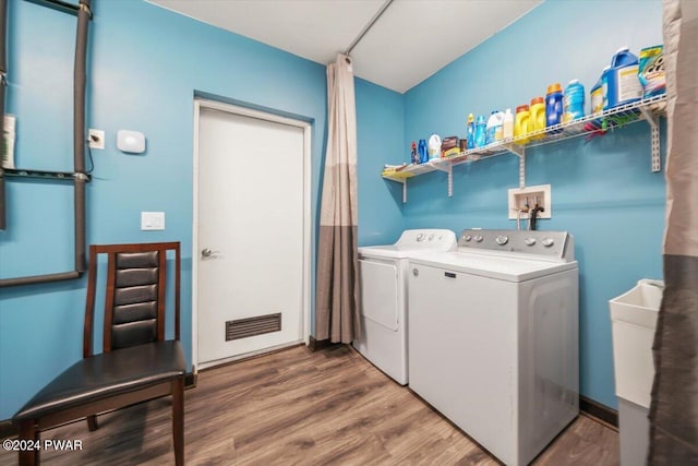 clothes washing area featuring separate washer and dryer and hardwood / wood-style floors